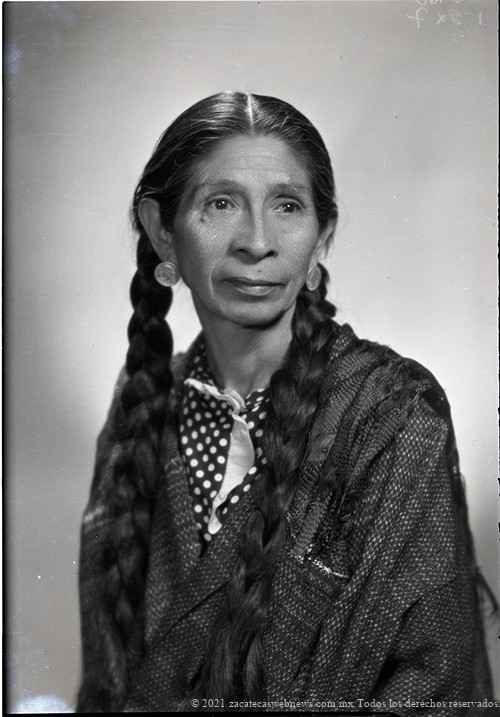 Retrato de mujer adulta no identificada con vestido estampado, rebozo, peinado con trenzas, y aretes hechos con monedas de 25 centavos de dólar, en estudio. Julio de 1945. Fresnillo, Zacatecas Foto: Ricardo Sánchez Ortega. No. inv. 16828. Fototeca del Estado de Zacatecas Pedro Valtierra.